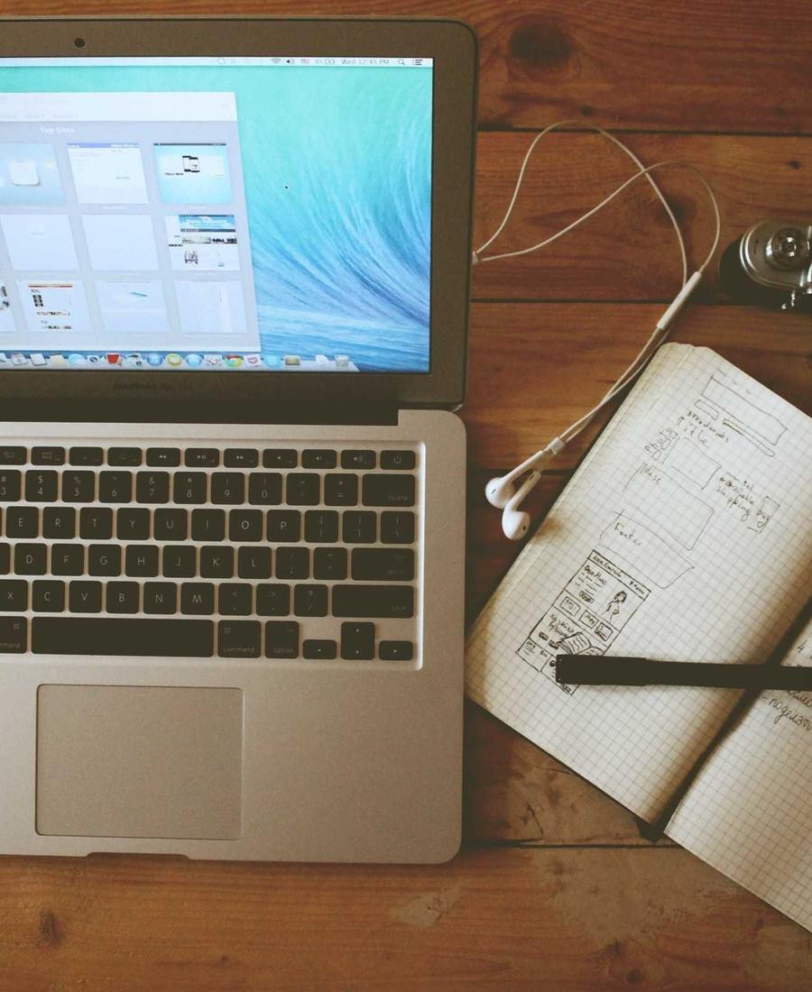 Notebook aberto ao lado de um caderno de anotações